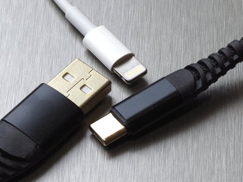 USB type C and lightning cable connector on a gray metal background